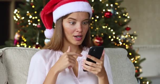 Sorprendido adolescente femenino recibir oferta de ventas de Navidad de temporada por celular — Vídeos de Stock