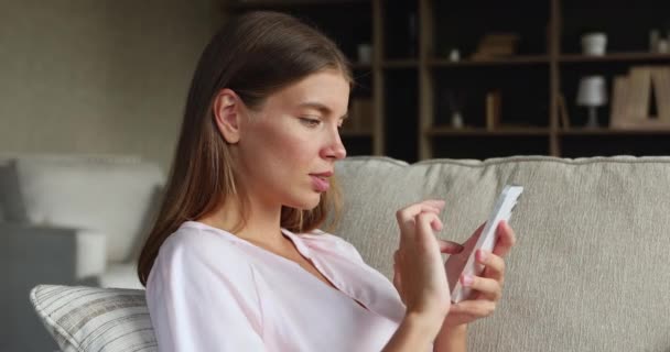 Вид збоку підліткової жінки задоволений користувачем сучасного смартфона — стокове відео