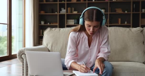 Gen z vrouw in headset studie op afstand met behulp van laptop — Stockvideo