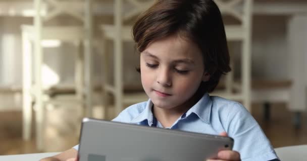 Kleiner entzückender Schüler mit digitalem Computer-Tablet. — Stockvideo