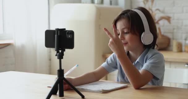 Menino criança adorável inteligente em fones de ouvido estudando distantemente. — Vídeo de Stock