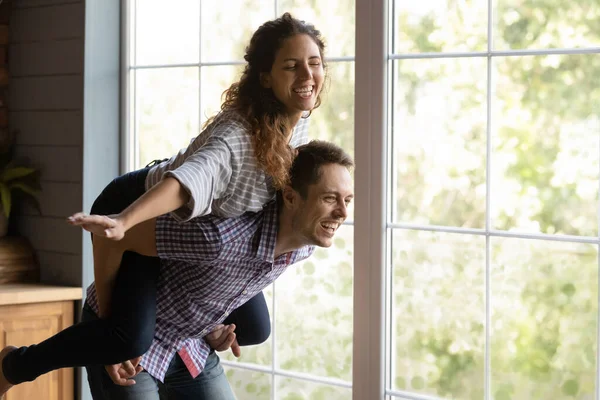 Playful young hispanic family couple having fun near huge window. — Stock Photo, Image