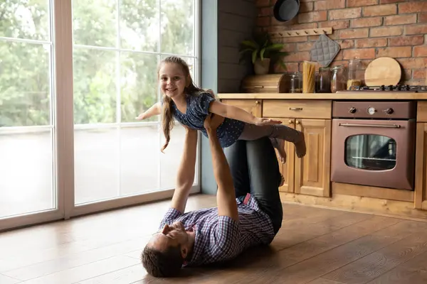 Alegre padre joven levantamiento en el aire adorable niño pequeño. — Foto de Stock