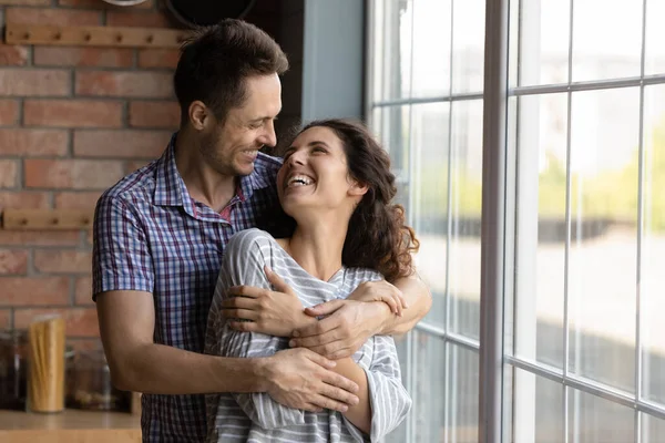 Zärtlich glücklicher junger Mann kuschelt lächelnd attraktive Frau. — Stockfoto