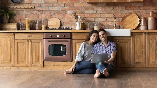 Portrait of smiling young hispanic family couple sitting on floor. — Stock Photo, Image