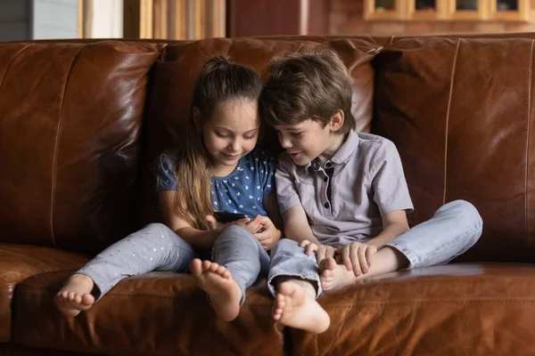 Happy schattige kleine kinderen spelen games op mobiele telefoon. — Stockfoto