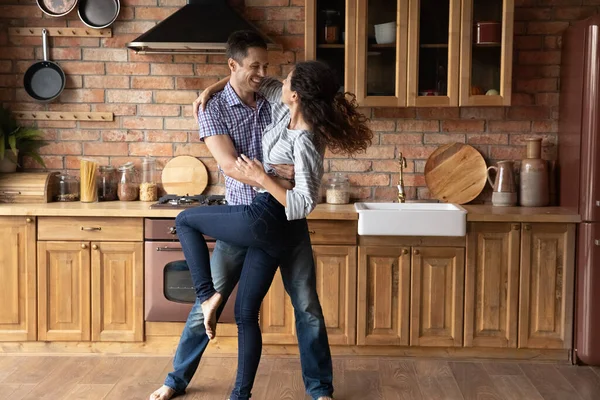 Счастливая романтическая молодая пара танцует на отремонтированной кухне. — стоковое фото