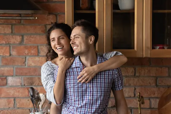 Glückliche schöne lateinische Frau kuschelt von hinten aufrichtig lächelnd Ehemann. — Stockfoto