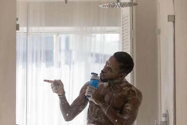 Muscular build African man singing in shower — Stock Photo, Image