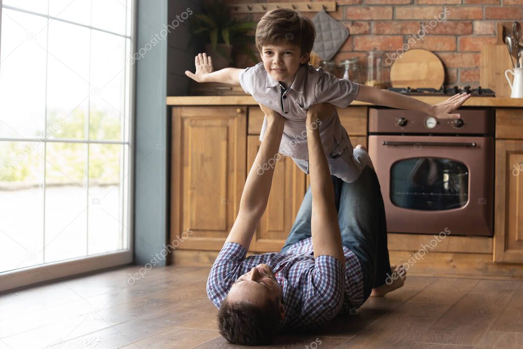 Happy young father carrying cute small kid son.