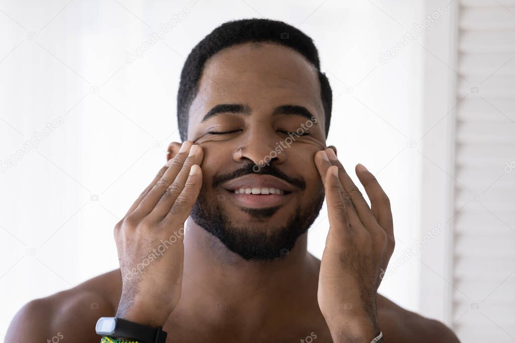 Handsome African man touch face massages smooth perfect skin