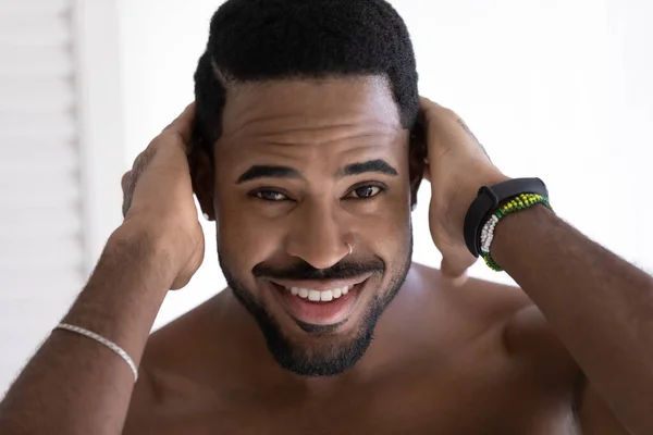 Shirtless bonito homem africano toca cabelo sorriso olha para a câmera — Fotografia de Stock