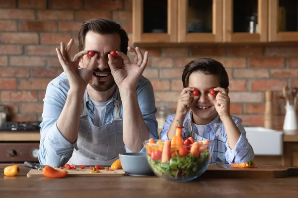 Huvudskott porträtt far och son har kul med tomater — Stockfoto