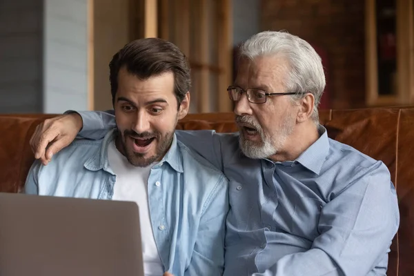 De cerca sorprendió a dos generaciones de hombres mirando a la computadora portátil — Foto de Stock