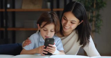 Evde cep telefonu kullanan mutlu melez bir aile..