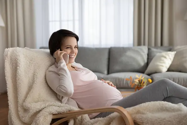 Sourire millénaire femme enceinte appeler gynécologue obtenir une consultation à distance — Photo