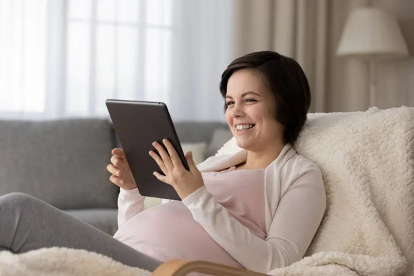 Mujer va a tener bebé disfrutar de una buena película en touchpad — Foto de Stock