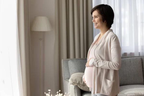 Carefree giovane incinta madre guardare la distanza piena di sogni — Foto Stock