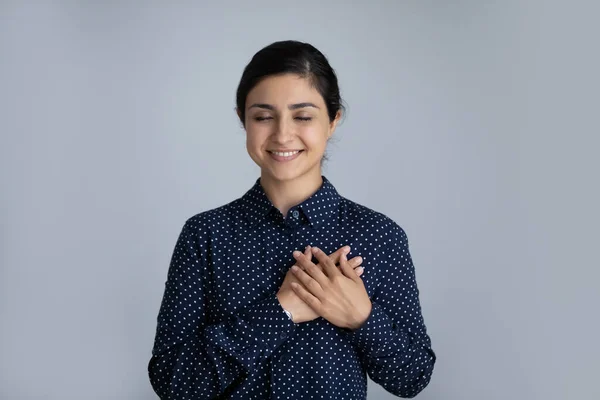 Cabeza disparada mujer india sonriente sosteniendo las manos en el pecho —  Fotos de Stock