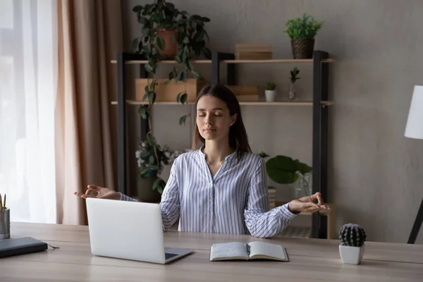 Mujer pacífica meditando, practicando yoga en casa oficina lugar de trabajo — Foto de Stock