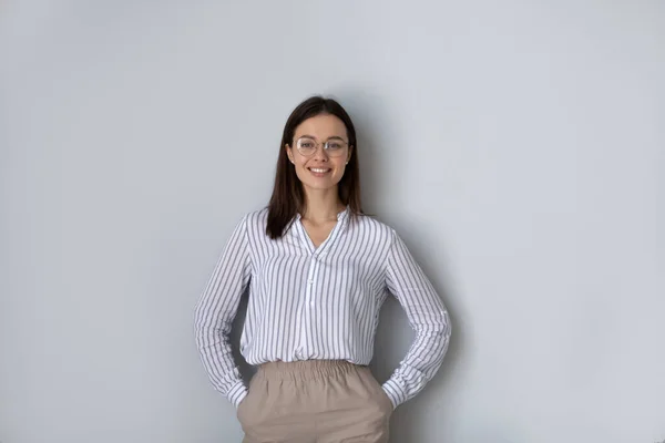 Portrait femme confiante dans des lunettes debout sur fond gris — Photo