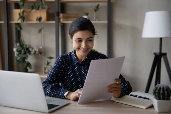 Sonriente mujer de negocios india leyendo documento, buenas noticias, haciendo papeleo — Foto de Stock