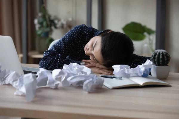 Уставшая индийская бизнесвумен спит на рабочем месте со смятыми бумагами — стоковое фото
