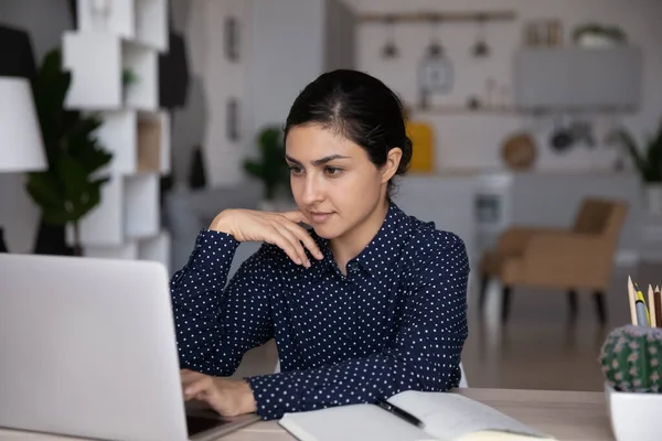 Pewna siebie Hinduska kobieta pracująca na laptopie, patrząca na ekran — Zdjęcie stockowe