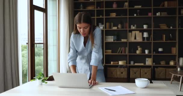 Мотивированная молодая женщина ходить рядом с ноутбуком записывать идеи — стоковое видео