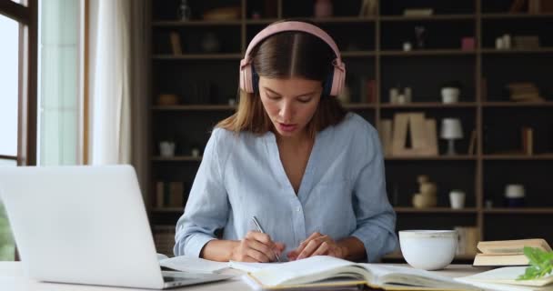 Joven maestra en auriculares dan clase desde casa en línea — Vídeos de Stock