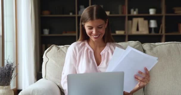 Milenyum kadını koltukta oturup bilgisayarını kullanarak evrak işleriyle meşgul. — Stok video