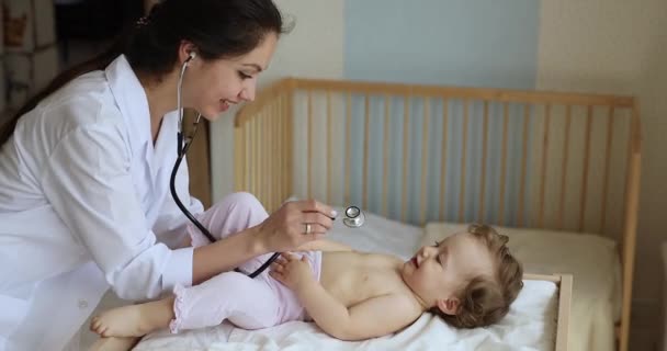 聴診器を持つ女性小児科医は、赤ちゃんの健康診断を行います — ストック動画