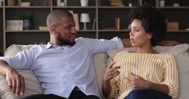 Αφρικάνικο ζευγάρι μιλάει κάθονται στον καναπέ στο μοντέρνο σαλόνι — Αρχείο Βίντεο