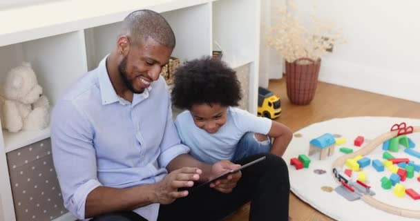 Afrikanischer Junge und sein Vater haben Spaß mit digitalem Tablet — Stockvideo