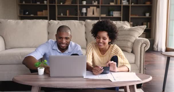 Африканская пара осуществляет платежи через электронный банк на ноутбуке — стоковое видео