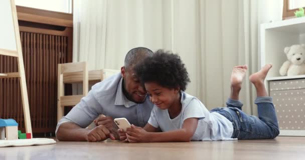 Africano homem e filho se divertindo em casa usando smartphone — Vídeo de Stock