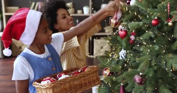 Mãe e filha africana decorando árvore de Natal em casa — Vídeo de Stock