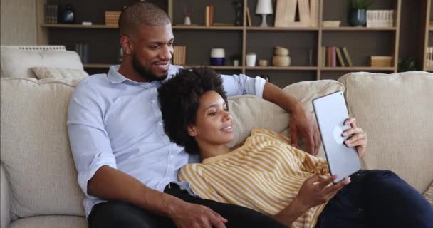 Обачна африканська пара проводить ліниві вихідні, користуючись цифровою табличкою. — стокове відео