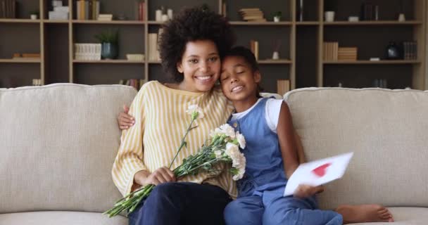 Жінка і дочка обіймають квіти і листівку — стокове відео