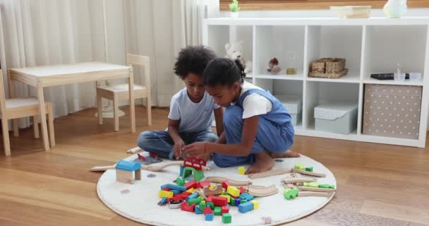 Afrikanische Kinder spielen Eisenbahn auf dem Boden im Spielzimmer — Stockvideo