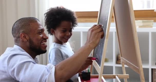 Papa africain et petit fils dessinant à bord avec des craies — Video