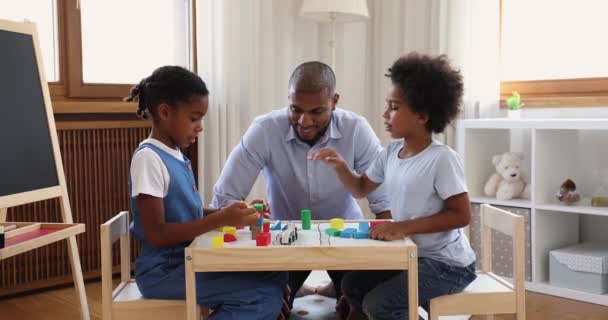Afrikanische Kinder und Vater spielen Holzspielzeug-Set im Kinderzimmer — Stockvideo