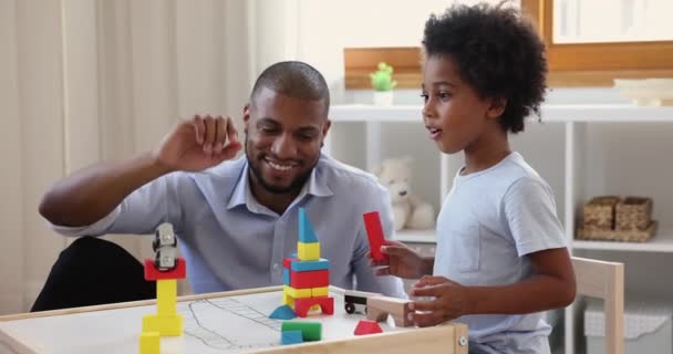 Africano padre jugar madera ladrillos con poco 7s lindo hijo — Vídeos de Stock