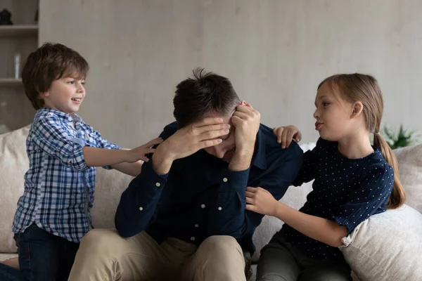 Unzufriedener junger alleinerziehender Vater irritiert über freche Kinder. — Stockfoto