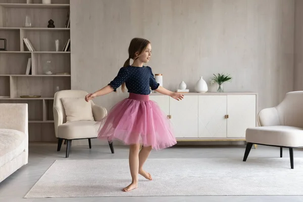 Gadis kecil yang gembira menari di ruang tamu modern. — Stok Foto