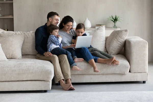 Glad kärleksfull latinamerikansk familj använder dator hemma. — Stockfoto