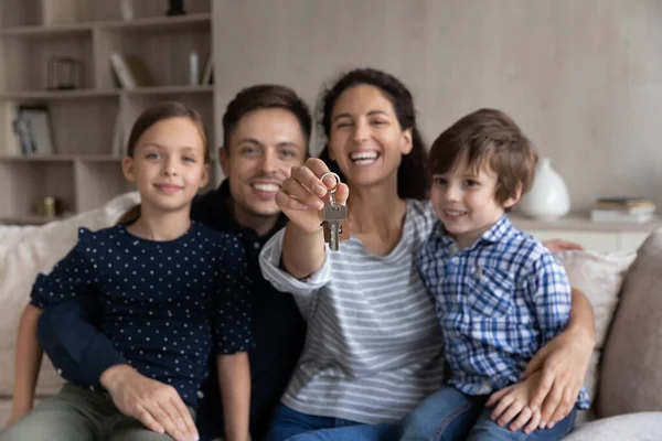 Retrato de família sorridente com crianças mostrando chaves. — Fotografia de Stock