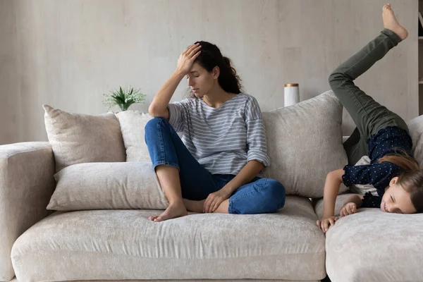 Zenuwachtig jong Spaans moeder gevoel uitgeput van ondeugend kind. — Stockfoto