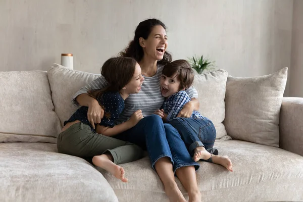 Överlycklig ung latinamerikansk mamma har kul med skrattande små barn. — Stockfoto