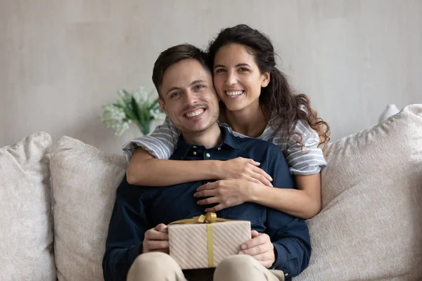 Retrato de jovem casal afetuoso com presente embrulhado. — Fotografia de Stock